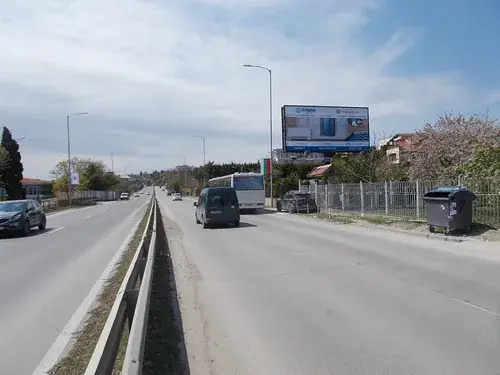 Мегаборд край градски булевард с преминаващи автомобили и автобус